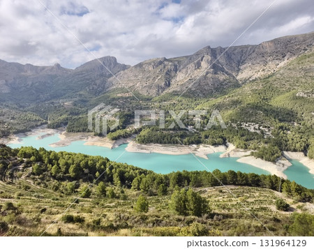 Experience the stunning beauty of a mountain lake with emerald waters surrounded by pristine nature Experience the stunning beauty of a mountain lake with emerald waters surrounded by pristine nature 131964129