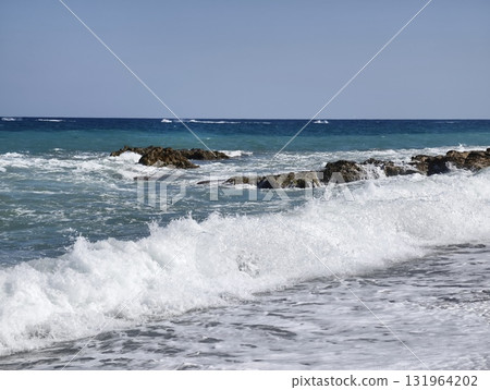 Experience the serene ocean waves gracefully crashing on the beautiful rocky shoreline Experience the serene ocean waves gracefully crashing on the beautiful rocky shoreline 131964202