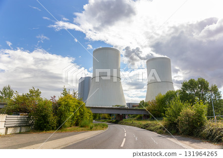 Massive cooling tower power plant Saxony Germany releasing steam cloudy sky. Industrial complex surrounded by fields illustrates modern energy generation, infrastructure environmental technology Massive cooling tower power plant Saxony Germany releasing steam cloudy sky. Industrial complex surrounded by fields illustrates modern energy generation, infrastructure environmental technology 131964265