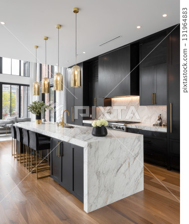 contemporary kitchen with stunning white marble waterfall island complemented by sleek black cabinetry. Gold-toned hardware and pendant lighting, touch of luxury. 131964883