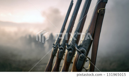 A close-up shot of several historical rifles with detailed engravings, leaning together against a foggy and blurred background of a battlefield. Historical re-enactment, war, or military theme A close-up shot of several historical rifles with detailed engravings, leaning together against a foggy and blurred background of a battlefield. Historical re-enactment, war, or military theme 131965015