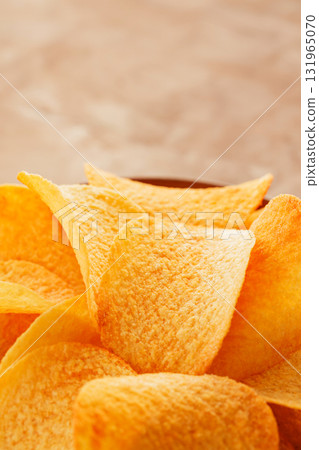 Crispy Golden Potato Chips in Bowl on Beige Background Close-Up Crispy Golden Potato Chips in Bowl on Beige Background Close-Up 131965070
