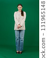 Set of photos of young European woman in light blazer and blue jeans showing various emotions gestures and expressions on green chroma key background with copy space for advertising and social media 131965148