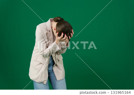 Set of photos of young European woman in light blazer and blue jeans showing various emotions gestures and expressions on green chroma key background with copy space for advertising and social media 131965164