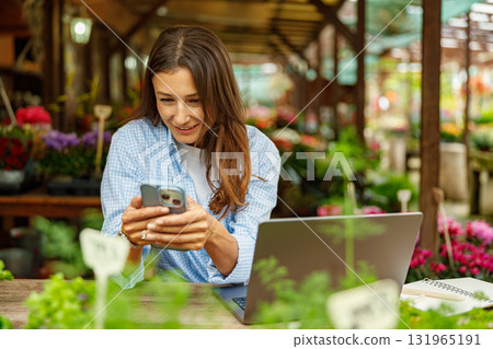 A woman is engaged in digital work while surrounded by the beauty of nature and greenery 131965191