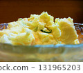 Potato salad served in a glass bowl. A photo of potato salad taken against the light, giving it a sizzling look. 131965203