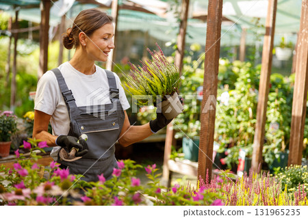 A Young Woman Engaged in Working at a Beautiful Flower Nursery Surrounded by Natures Beauty 131965235
