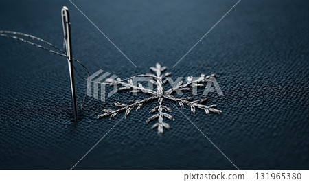 A shiny silver sewing needle pierces dark blue textured fabric, intricately embroidering a delicate silver snowflake pattern with shimmering thread. A shiny silver sewing needle pierces dark blue textured fabric, intricately embroidering a delicate silver snowflake pattern with shimmering thread. 131965380