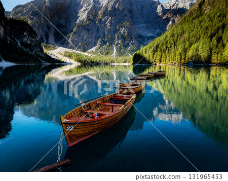 A Serene Mountain Lake Surrounded by Wooden Boats in a Stunning Natural Landscape View 131965453