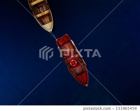 A breathtaking aerial view showcasing numerous boats gracefully floating on the deep blue water A breathtaking aerial view showcasing numerous boats gracefully floating on the deep blue water 131965459