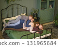 Parents and sons are lying next to each other on a bedroom bed decorated for New Year and Christmas. Happy happy family on the weekend 131965684