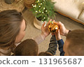 Reflection of a family with their sons in a golden Christmas tree toy balloon. The atmosphere of New Year and Christmas 131965687