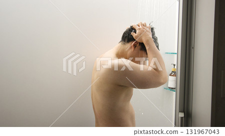A man in his twenties taking a shower 131967043
