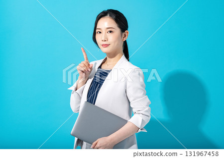 一位穿著西裝的職業女性指著並介紹某樣東西 131967458