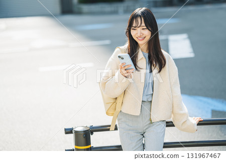 Young woman looking at smartphone in the city Young woman looking at smartphone in the city 131967467