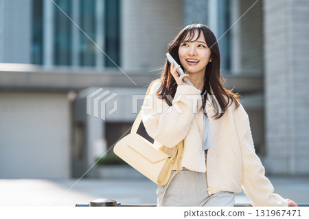 一名二十多歲的年輕女性正在用智慧型手機聊天 一名二十多歲的年輕女性正在用智慧型手機聊天 131967471