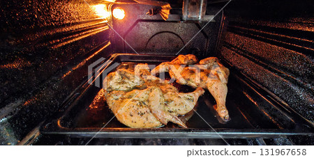 Chicken roasting in oven.  Two tobacco chickens on a baking sheet in the oven. 131967658