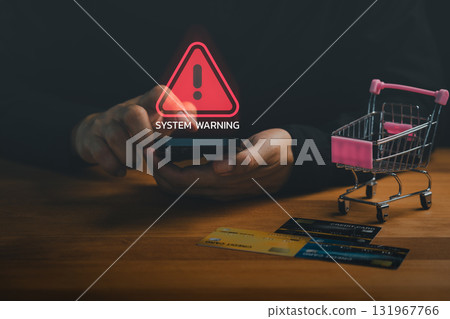 Customer using mobile phone with system warning icon, credit cards, and shopping cart symbolizing online fraud, cyber security risk, financial scam, payment danger and e-commerce security warning. Customer using mobile phone with system warning icon, credit cards, and shopping cart symbolizing online fraud, cyber security risk, financial scam, payment danger and e-commerce security warning. 131967766