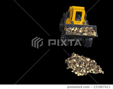 A creative and unique macro studio shot of a miniature yellow and grey plastic toy construction front loader, isolated against a dramatic black background, scooping a mound of whole black peppercorns. A creative and unique macro studio shot of a miniature yellow and grey plastic toy construction front loader, isolated against a dramatic black background, scooping a mound of whole black peppercorns. 131967821