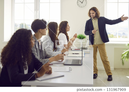 Group of diverse teenage students together with teacher having discussion in class Group of diverse teenage students together with teacher having discussion in class 131967909