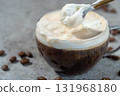 Scooping cream from a Viennese coffee (Einspäner) with a spoon 131968180