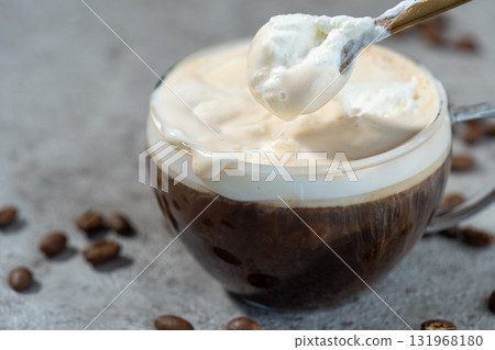 用湯匙從維也納咖啡(Einspäner)中舀出奶油 用湯匙從維也納咖啡(Einspäner)中舀出奶油 131968180