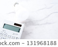 A calculator and a light bulb, representing rising electricity bills 131968188