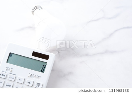 A calculator and a light bulb, representing rising electricity bills 131968188