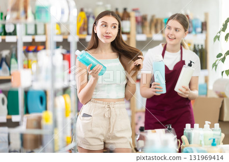 Woman seller offers shampoo to young woman buyer 131969414