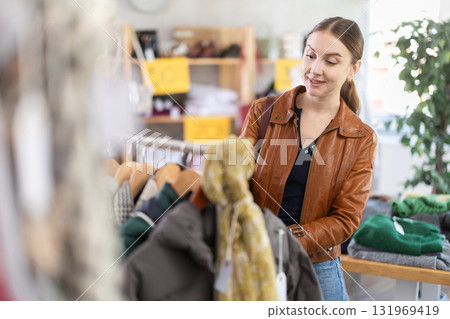 Woman choosing outerwear in a store Woman choosing outerwear in a store 131969419