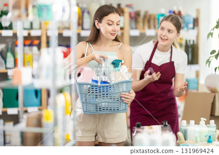 Young woman seller offers household chemicals to woman Young woman seller offers household chemicals to woman 131969424