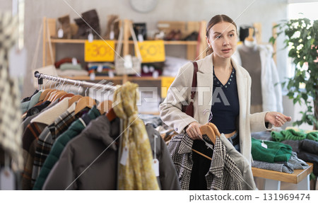 Woman choosing outerwear in a store 131969474