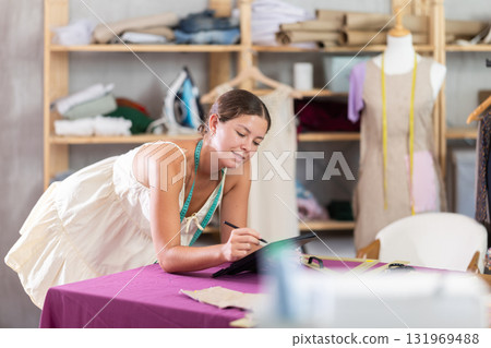 Woman dressmaker drawing on tablet 131969488