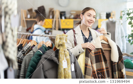 Young woman choosing a coat in a store Young woman choosing a coat in a store 131969494