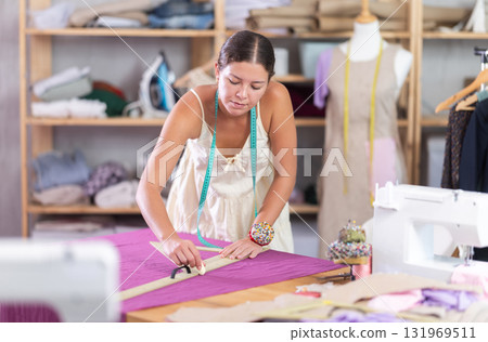 dressmaker marks and cuts the fabric 131969511