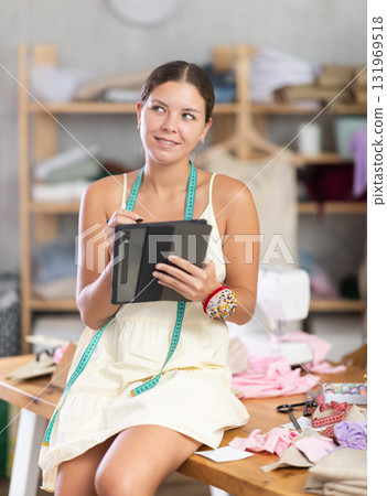 Woman dressmaker drawing on tablet 131969518
