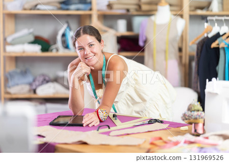 Female tailor create sketch of dress in tablet Female tailor create sketch of dress in tablet 131969526