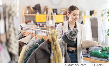 Adult woman choosing hat in clothing store 131969530