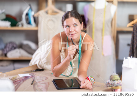 Woman dressmaker drawing on tablet 131969550