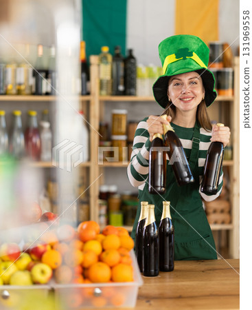 Positive friendly girl seller in traditional green Irish cap offers to buy Irish ale for St. Patrick Day celebration Positive friendly girl seller in traditional green Irish cap offers to buy Irish ale for St. Patrick Day celebration 131969558