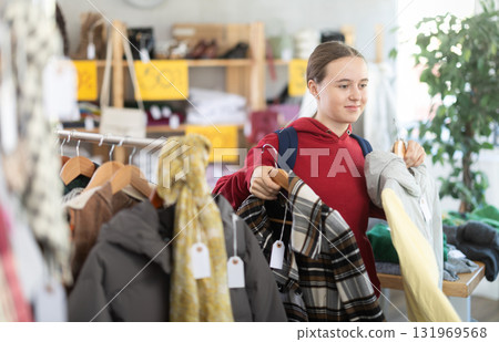 Teenage girl at winter clothes sale Teenage girl at winter clothes sale 131969568