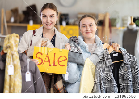 Adult woman and teenage girl holding sale sign 131969596
