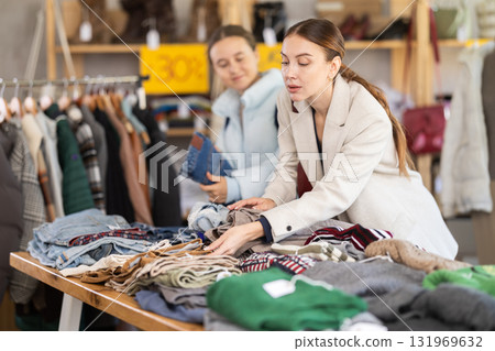 Adult woman and teenage girl choose trousers 131969632