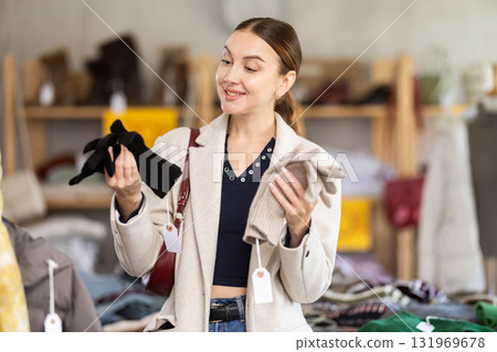 Young woman choosing winter gloves in clothing store Young woman choosing winter gloves in clothing store 131969678