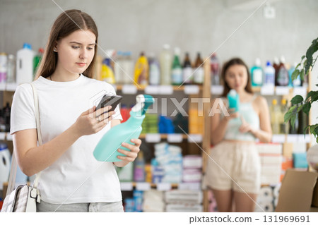 Young woman scanning qr code for cleaning spray Young woman scanning qr code for cleaning spray 131969691