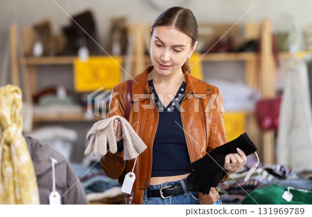 Adult woman choosing gloves in clothing store 131969789