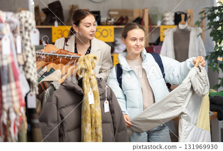Adult woman and teenage girl choose down jacket 131969930