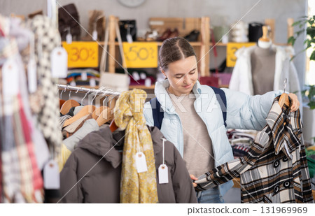Teenage girl choosing flannel shirt 131969969