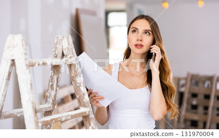 Woman having telephone convesrtion in construction site Woman having telephone convesrtion in construction site 131970004