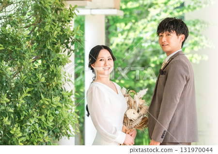Bride and groom staring at each other with a bouquet (wedding, bridal, couple) 131970044